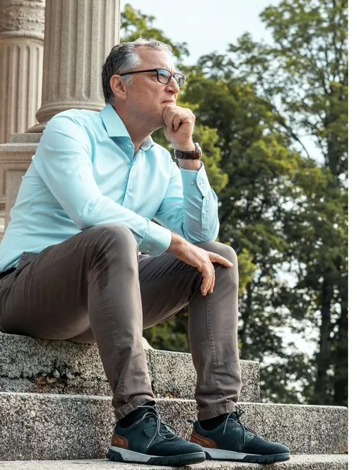 Sebastian Morgner sitzt nachdenklich auf einer Treppe